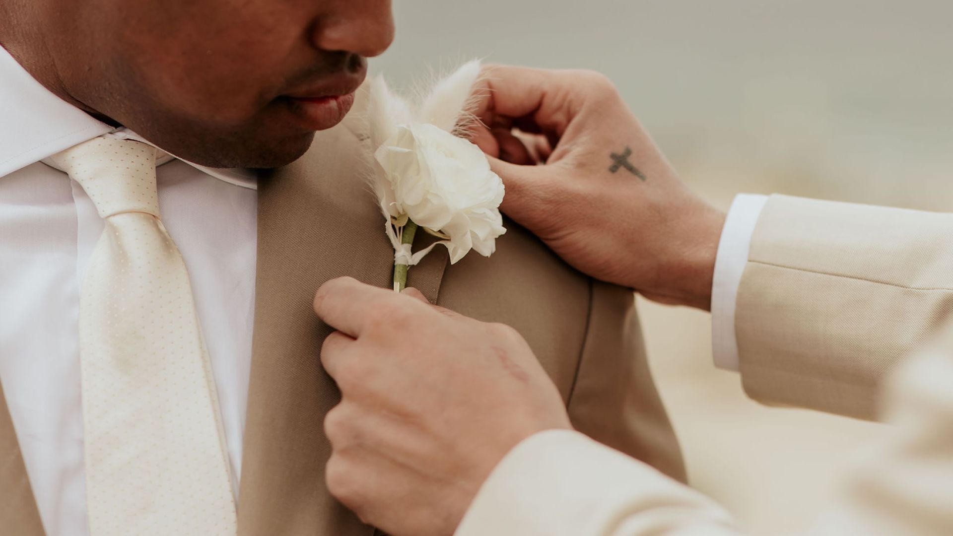 A Person In A Suit Holding A White Flower