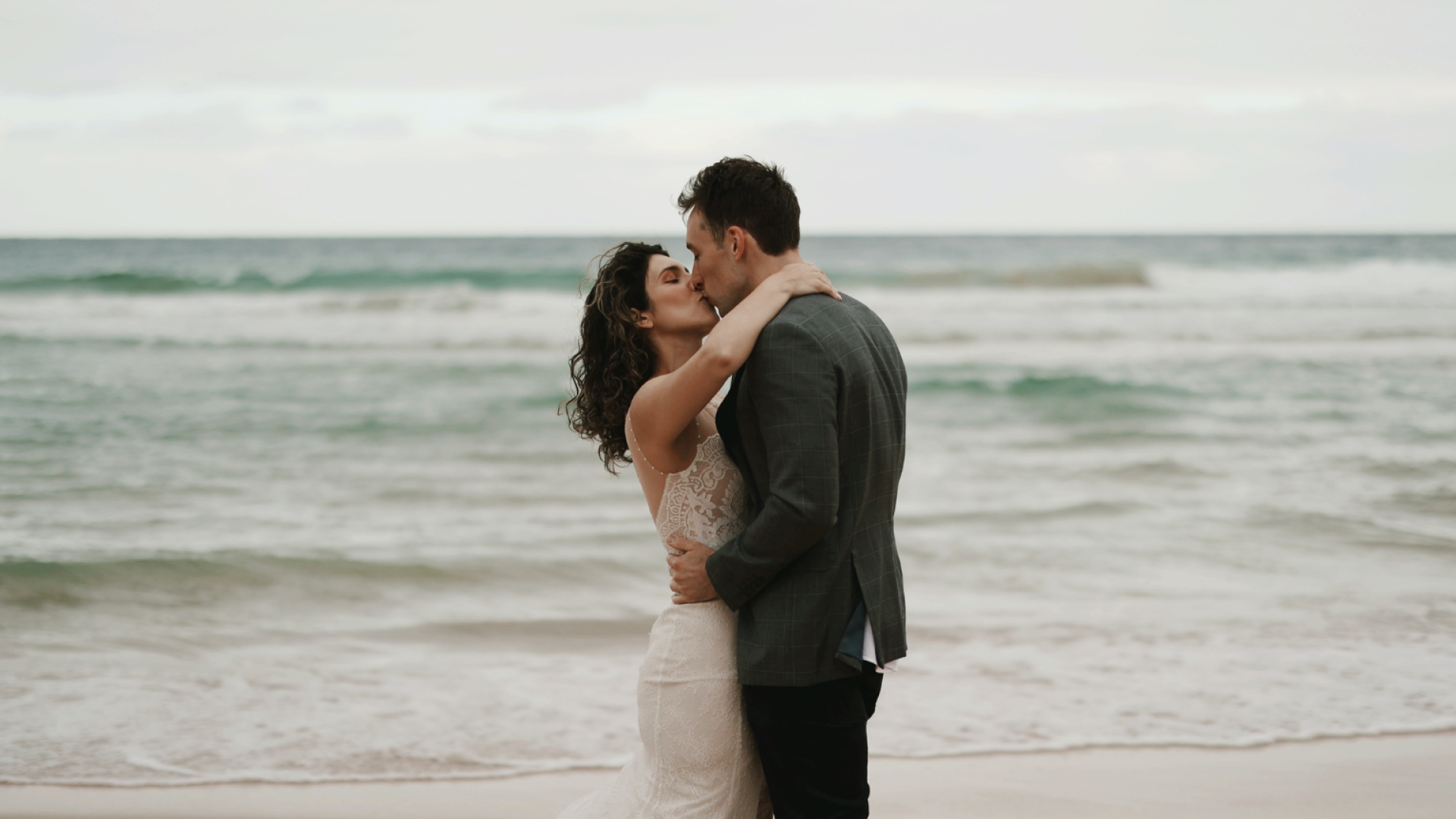 A Man And Woman Kissing On A Beach